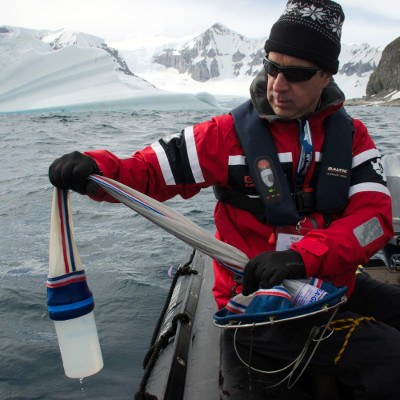 citizen scientist in Antarctica taking water sample