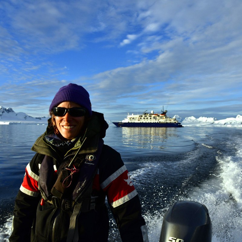 Antarctic kayakers navigating around iceberg